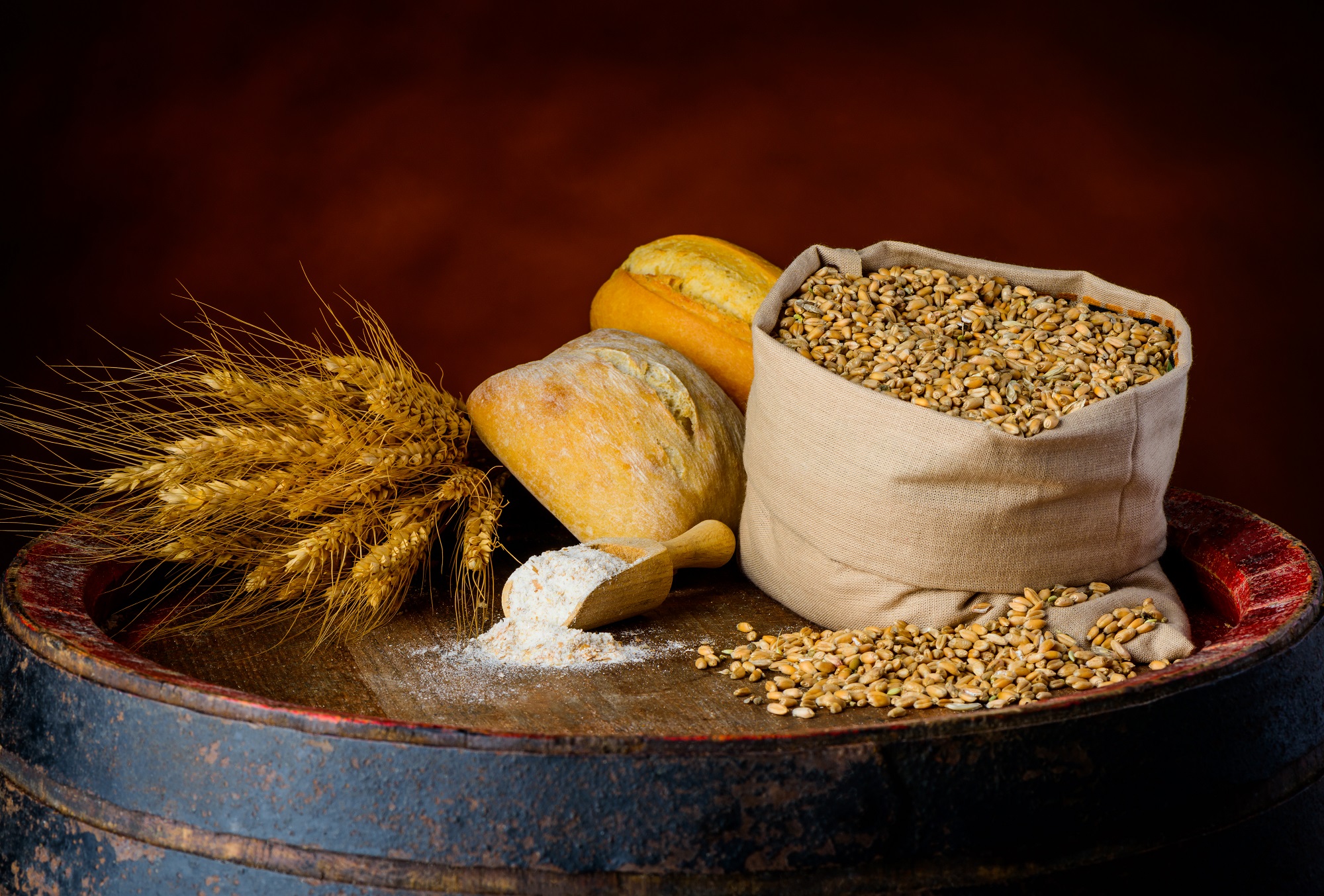 Cereal products, wheat bun, cereal-grain, flour on a wooden barrel in a rustic setup